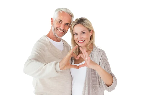 Happy couple forming heart shape with hands — Stock Photo, Image