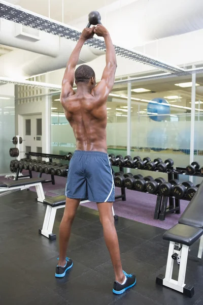 Muscular man lifting kettle bell — Stock Photo, Image