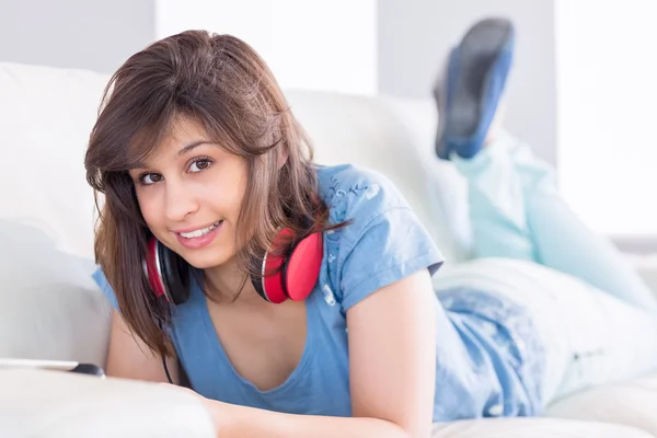 Hübsche Brünette mit Tablet-PC auf der Couch — Stockfoto