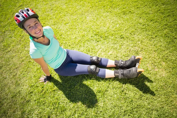 Подходит зрелая женщина в роликовых коньках на траве — стоковое фото