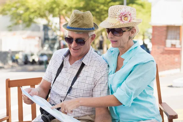 Felice coppia turistica guardando la mappa in città — Foto Stock