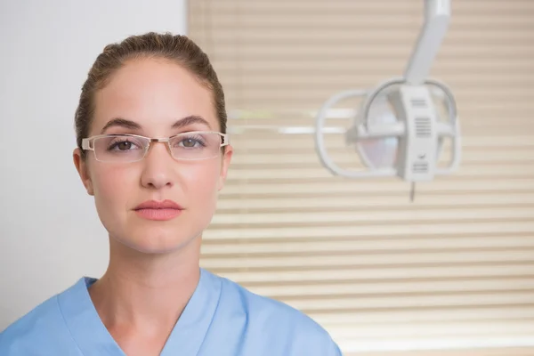Tandläkare i blå scrubs tittar på kameran — Stockfoto