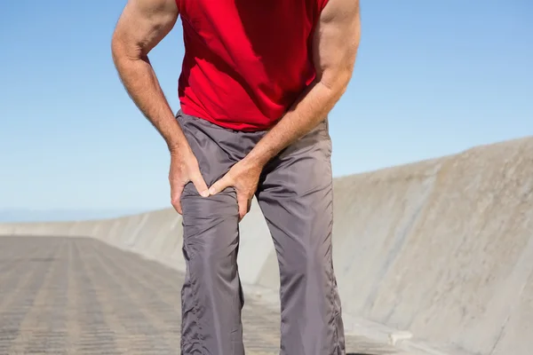 Homme âgé actif touchant sa cuisse blessée — Photo