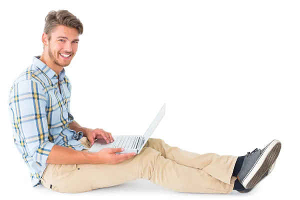 Schöner junger Mann sitzt mit Laptop — Stockfoto