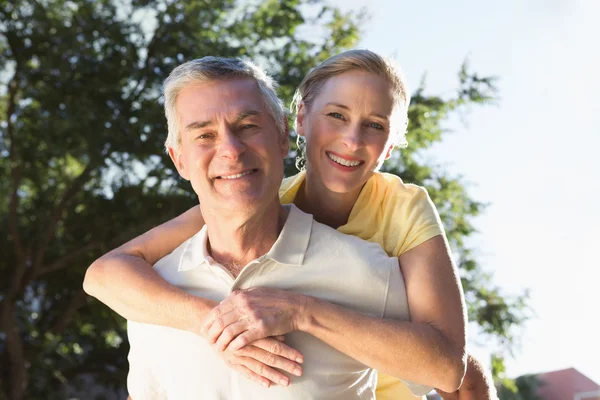 Glücklicher Senior gibt seiner Partnerin ein Huckepack zurück — Stockfoto