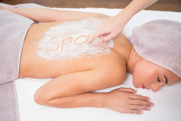 Attractive woman receiving back mask cream at spa center — Stock Photo, Image