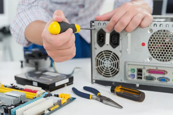 Young technician working on broken computer — Stock Photo, Image