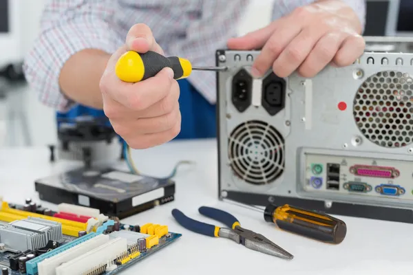 Jovem técnico trabalhando em computador quebrado — Fotografia de Stock