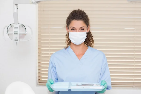 Dentista em esfrega azul segurando bandeja de ferramentas — Fotografia de Stock