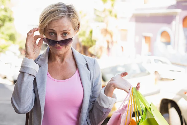 Gelukkig volwassen vrouw die lacht op camera met haar winkelen aankopen — Stockfoto