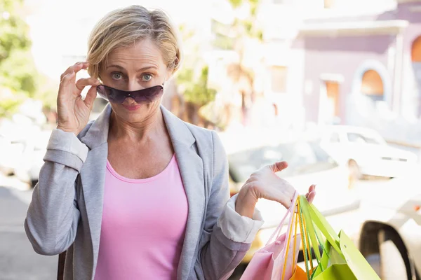 Mulher madura feliz sorrindo para a câmera com suas compras — Fotografia de Stock