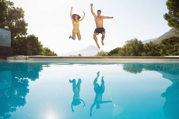 Casal pulando na piscina — Fotografia de Stock