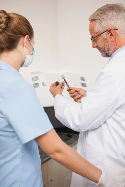 Dentista e assistente estudando raios-X — Fotografia de Stock