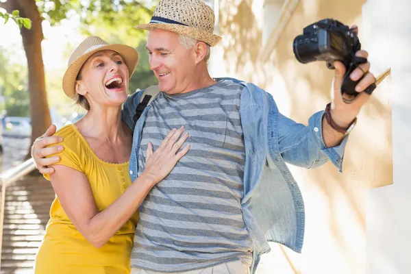 Feliz pareja de turistas tomando una selfie en la ciudad —  Fotos de Stock