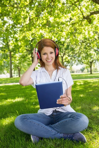 Redhead using her tablet pc 免版税图库照片