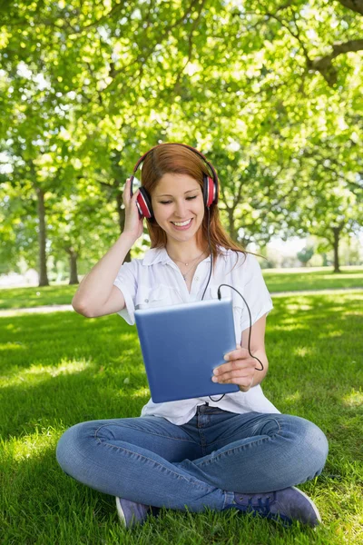 Redhead using her tablet pc 免版税图库图片