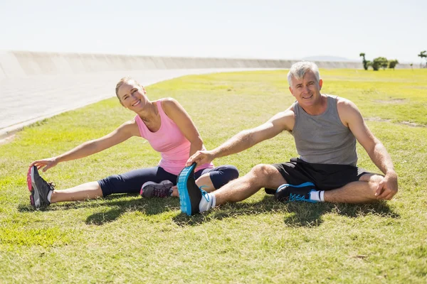 Fit mature couple warming up on the grass — Stock Photo, Image
