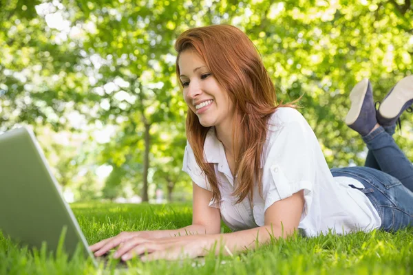 Redhead met laptop in het park — Stockfoto