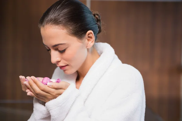 Schöne Frau riecht Blumen im Wellnessbereich — Stockfoto