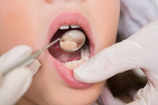 Dentista pediátrico examinando um dentes meninas — Fotografia de Stock