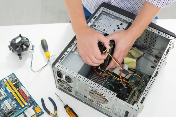 Jovem técnico trabalhando em computador quebrado — Fotografia de Stock