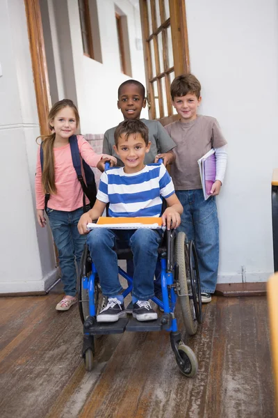 Ученик-инвалид со своими друзьями в классе — стоковое фото