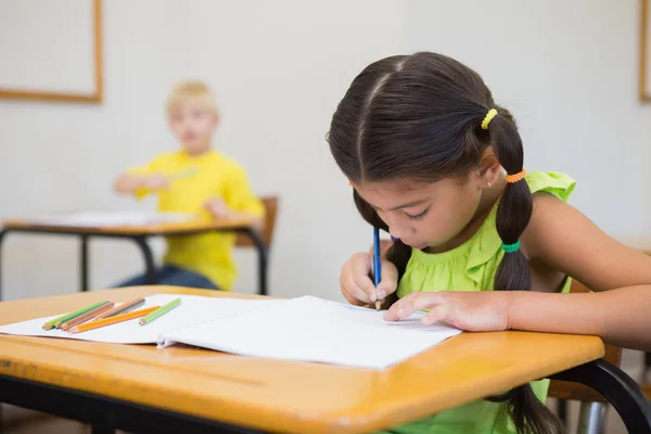 Allievi che colorano alle scrivanie in classe — Foto Stock