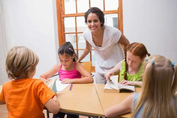 Leraar permanent met leerlingen aan balie — Stockfoto