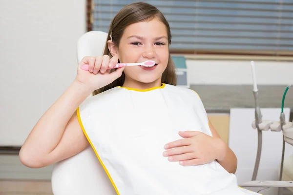 Mädchen hält Zahnbürste im Zahnarztstuhl — Stockfoto