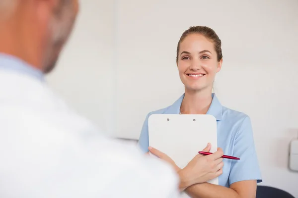 Dentista e assistente de frente um para o outro — Fotografia de Stock