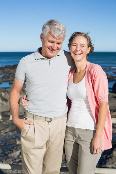 Heureux couple décontracté souriant à la caméra près de la côte — Photo