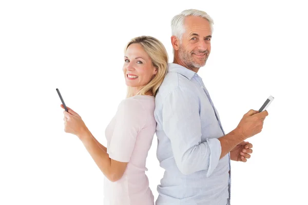 在他们的智能手机上对幸福的夫妇发短信 — 图库照片