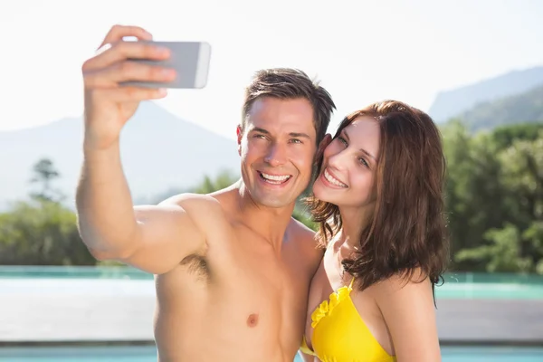 Paar nemen foto van zichzelf bij zwembad — Stockfoto
