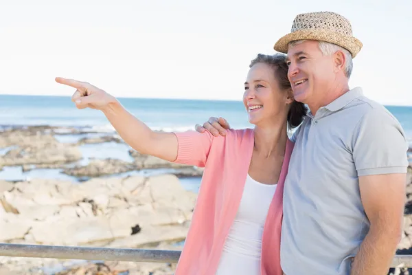 Pareja casual feliz mirando algo por la costa — Foto de Stock