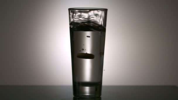 Яркие витаминные таблетки в стакане воды — стоковое видео