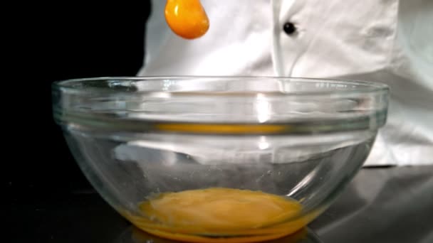 Chef adding raw egg to glass bowl — Stock Video
