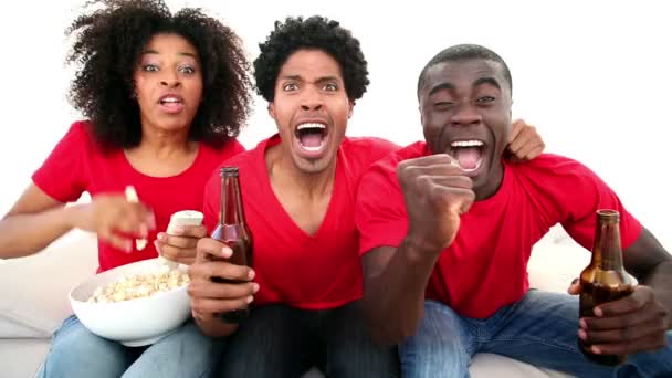 Los aficionados al fútbol en el sofá animando — Vídeos de Stock