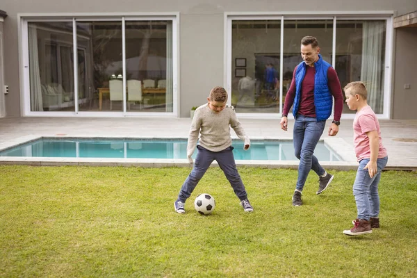 白人の父と2人の息子が庭で一緒にサッカーをしている 父親と愛の概念 — ストック写真