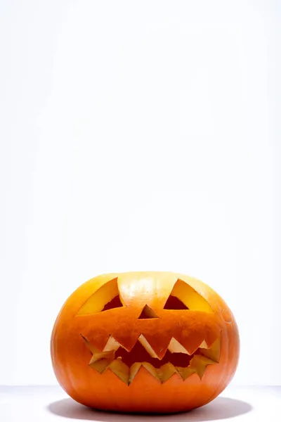 恐ろしいハロウィンの構成は 白い背景にオレンジ色のカボチャを彫りました ハロウィンの伝統とお祝いのコンセプト — ストック写真