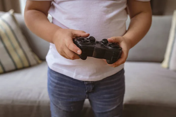 自宅でビデオゲームコントローラを保持少年のミッドセクション ゲームやエンターテイメントのコンセプト — ストック写真