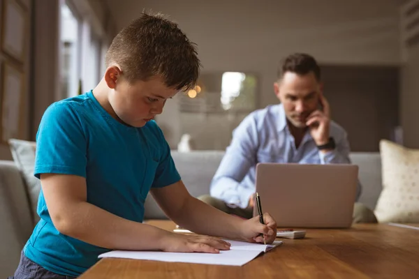 Pai Caucasiano Usando Laptop Enquanto Filho Fazendo Seus Trabalhos Casa — Fotografia de Stock