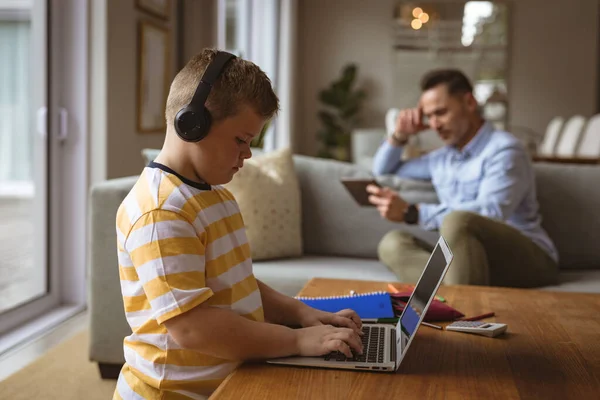 在家里客厅里 白人男孩戴着耳机 用笔记本电脑 家庭教育和教育概念 — 图库照片