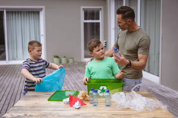 白人の父と2人の息子は屋外の袋にプラスチック材料を収集します プラスチックのリサイクルと汚染管理の概念 — ストック写真