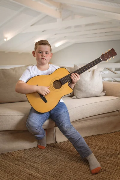 Retrato Menino Caucasiano Tocando Guitarra Sentado Sofá Casa Conceito Infância — Fotografia de Stock