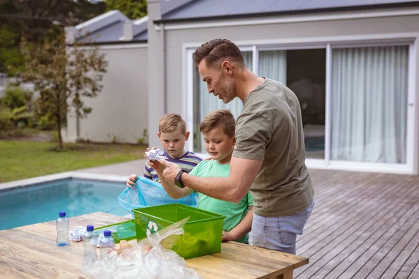 白人の父と2人の息子は屋外の袋にプラスチック材料を収集します プラスチックのリサイクルと汚染管理の概念 — ストック写真