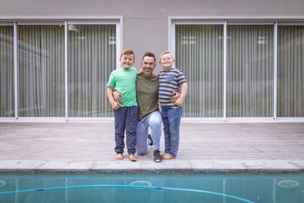 プールの近くに立っている間に手を笑顔を保持している白人の父と2人の息子の肖像画 父親と愛の概念 — ストック写真