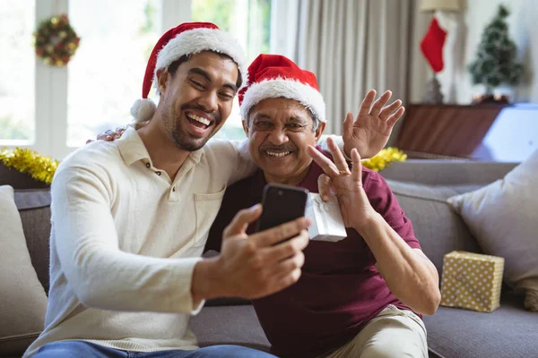 Gelukkige Biracial Volwassen Zoon Senior Vader Santa Hoeden Maken Smartphone — Stockfoto