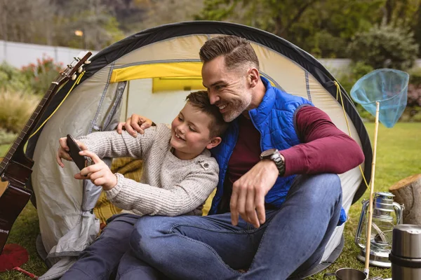 庭のテントに座っている間 白人の父と息子は自撮りをしました 父親と愛の概念 — ストック写真