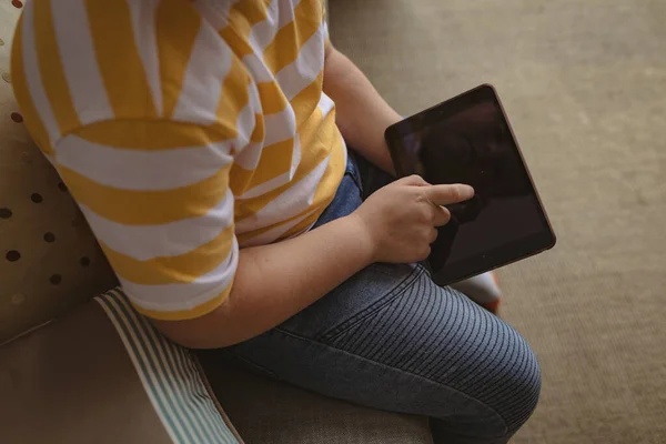 自宅のソファに座ってデジタルタブレットを使用して少年のミッドセクション 子供時代のコンセプト — ストック写真