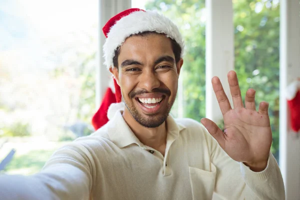 サンタの帽子の幸せな出産の男の肖像画はクリスマスビデオ通話を行います クリスマスやお祭りや通信技術は — ストック写真